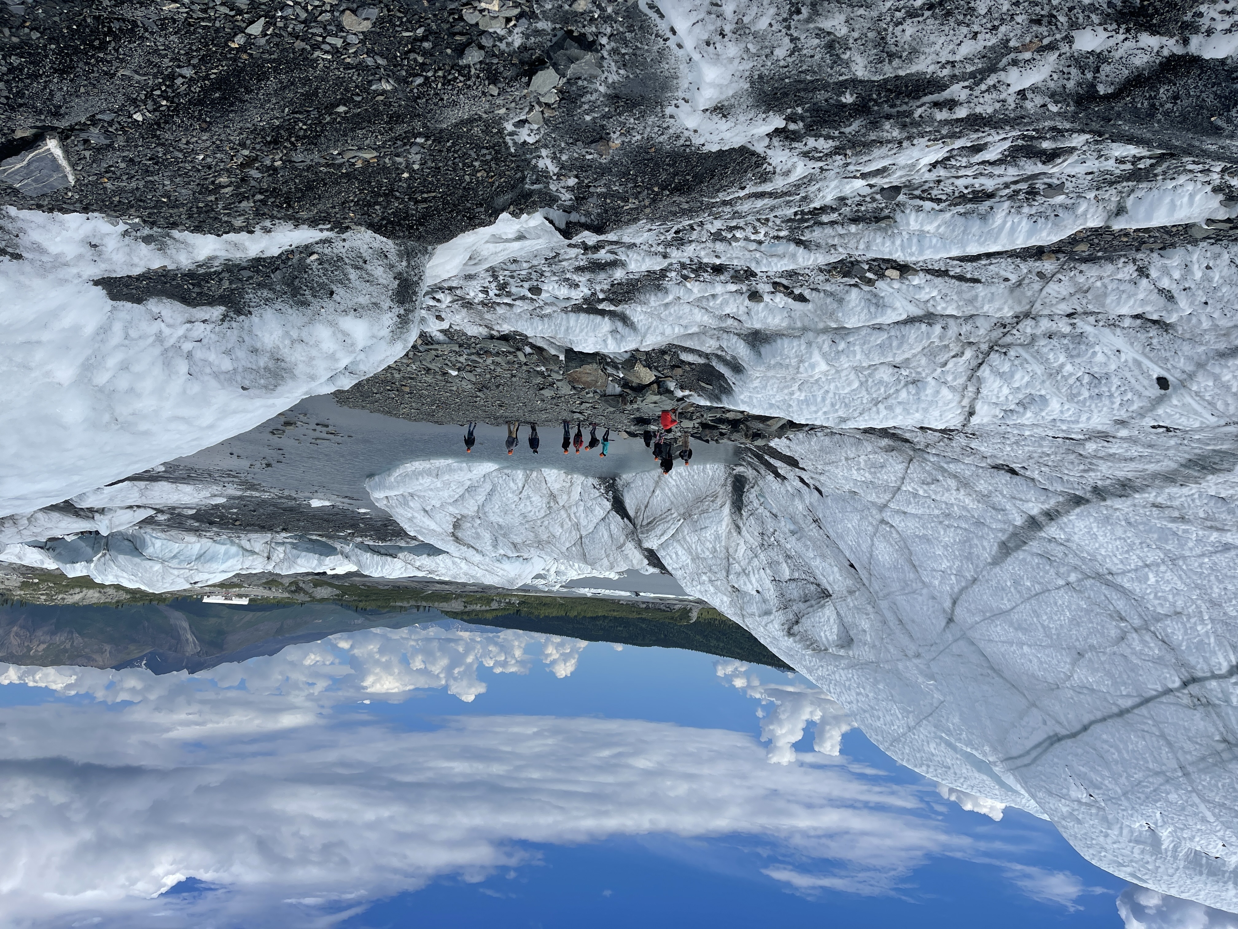 A group of 10 people walking on a glacier in Alaska