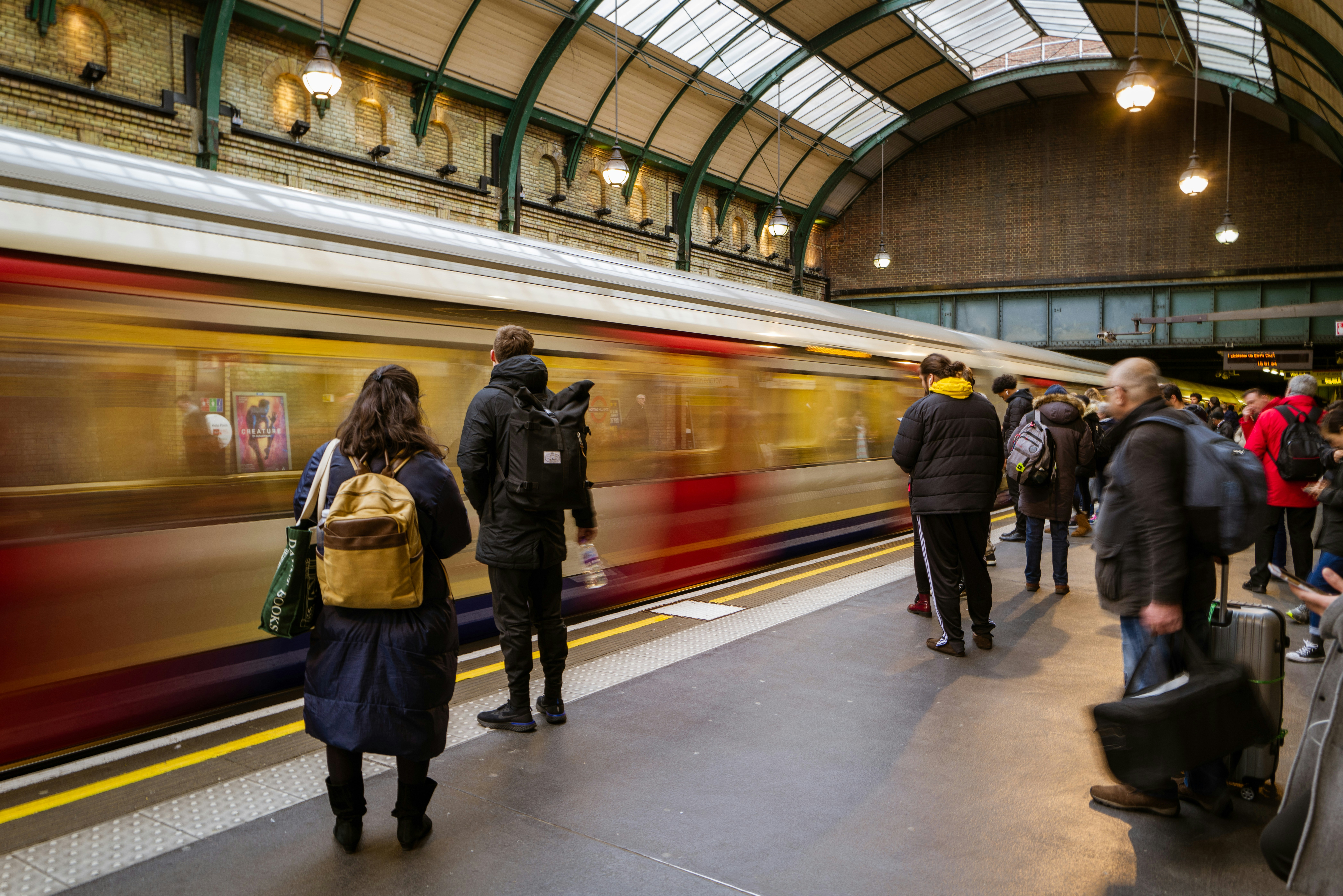 A group of people standing in a train station in London, England