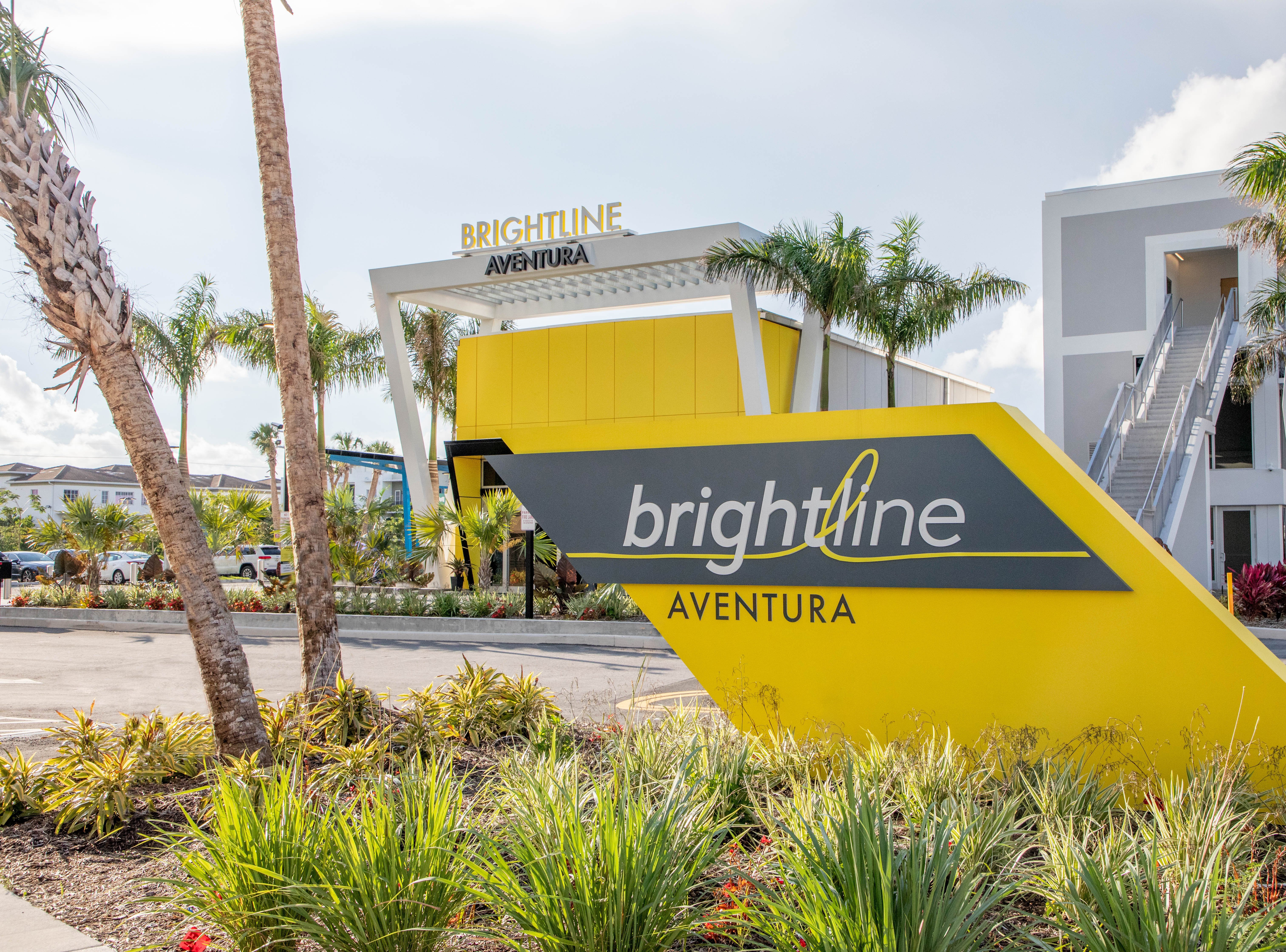 A yellow and grey sign in front of a building