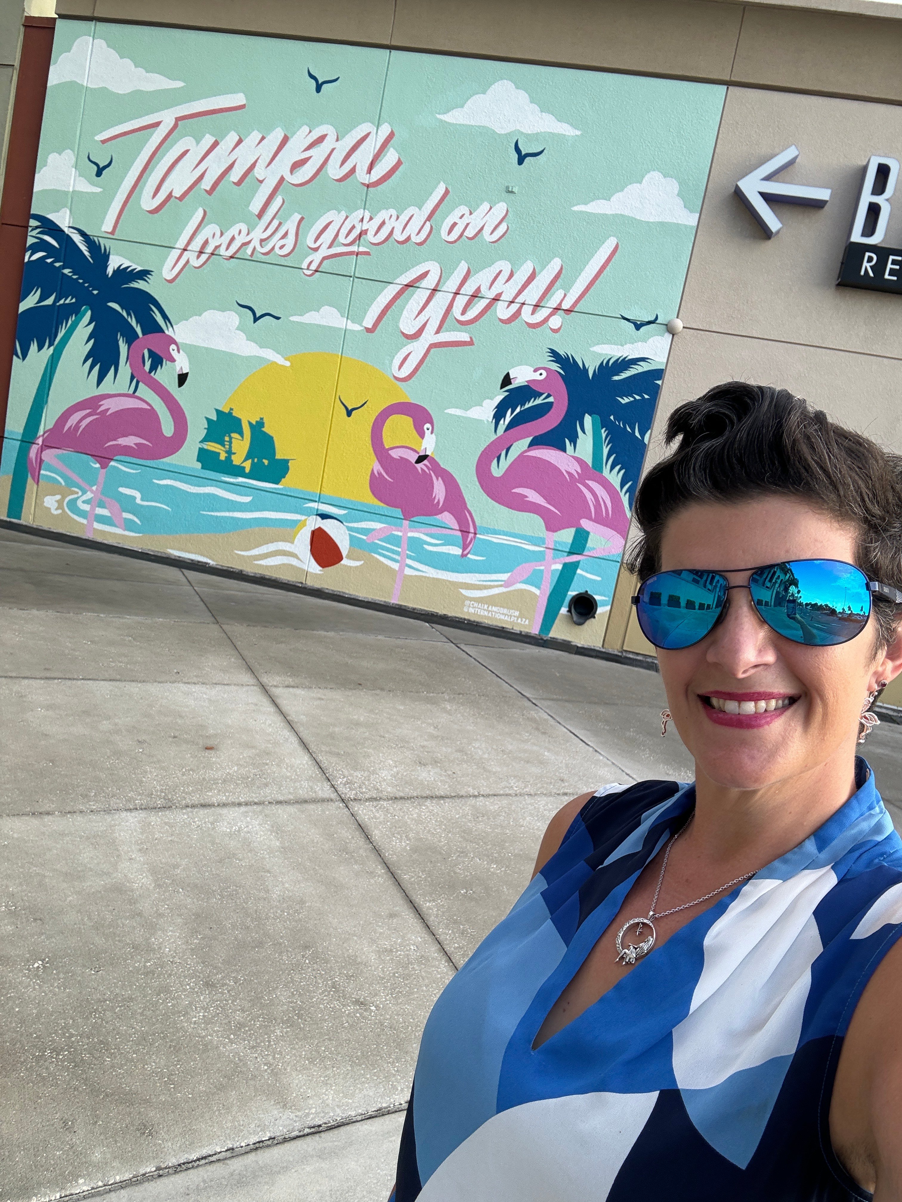 A woman takes a selfie by a mural in Tampa, Florida