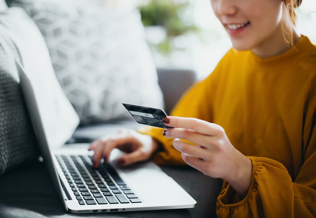 women typing in CC information into laptop