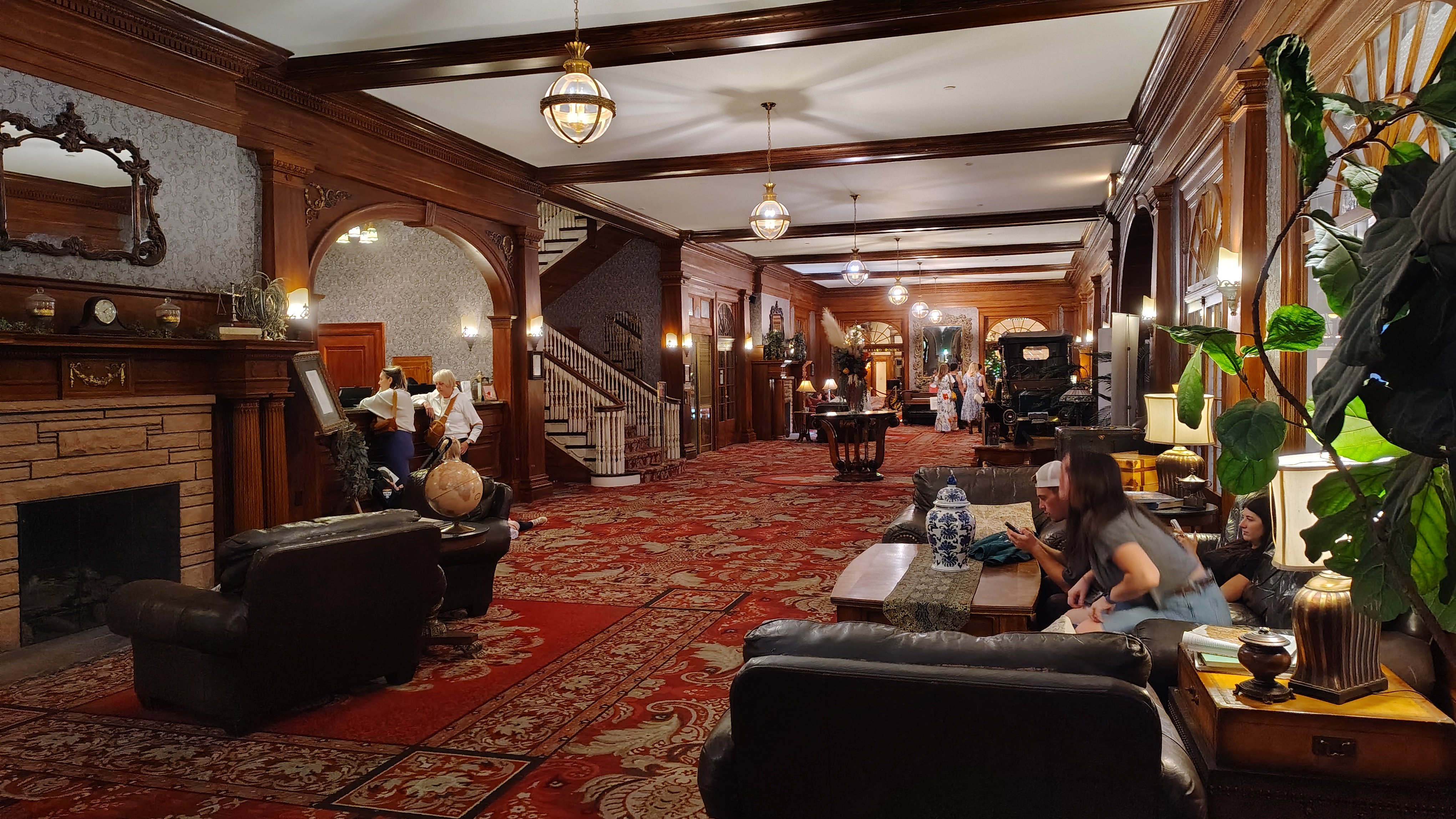 The lobby of The Stanley Hotel features red carpet, leather furnishings and dark woodwork