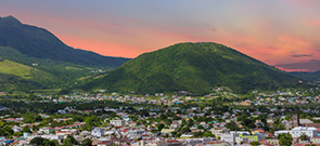 city with mountain in background at sunset