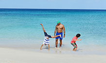 Family playing on the beach near the ocean