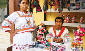 native people sitting a booth selling goods