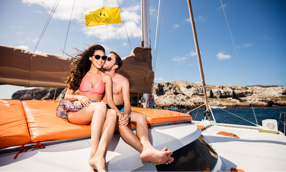 couple on a boat sitting by each other and kissing